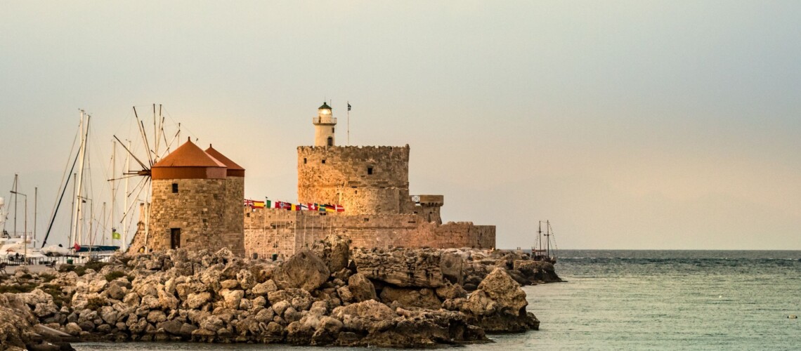 Windmills And The Lighthouse At Mandraki Harbour, Rhodes, Greece